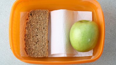 School lunch sparse orange lunch box with apple and slice