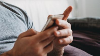 Man using his phone at home.