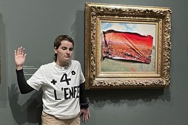 This photo provided by Riposte Alimentaire shows an environmental activist posing by &quot;Poppy Field&#x27;&#x27; by Claude Monet at the Orsay museum, Saturday, June 1, 2024 in Paris. 