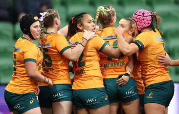 Desiree Miller of Australia is congratulated by teammates after scoring a try.
