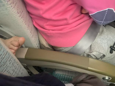 foot on armrest during flight from emirates