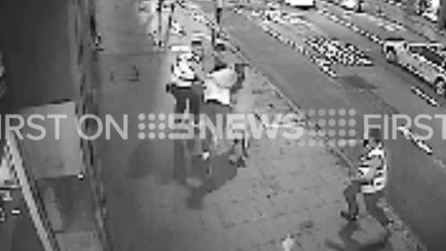 Several passers-by seem to be caught up by the fight. (9NEWS)