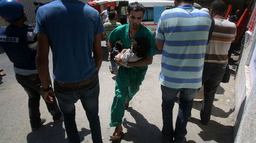 A Palestinian health worker helps an injured child following the latest Israeli assault in Gaza (Getty Images)
