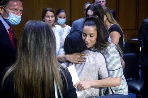 US Olympic gymnast Aly Raisman (center R) embraces Simone Biles after testifying during a Senate Judiciary hearing. 