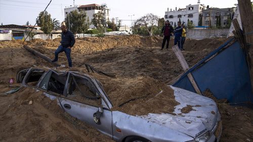 Palestinians inspect damage from overnight Israeli airstrikes in Gaza City.