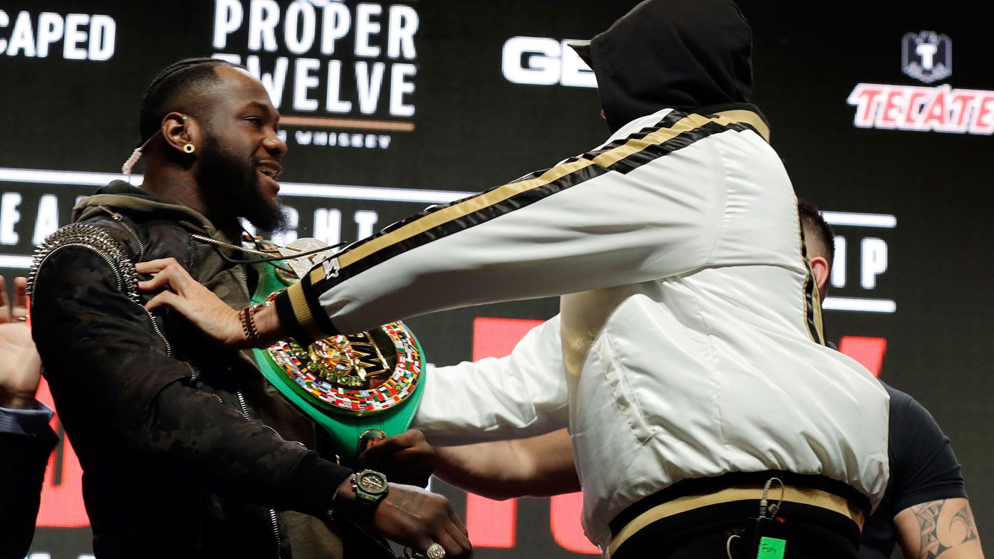 Tyson Fury, of England, right, shoves Deontay Wilder during a face off for photographers at a news conference for their upcoming WBC heavyweight championship bout