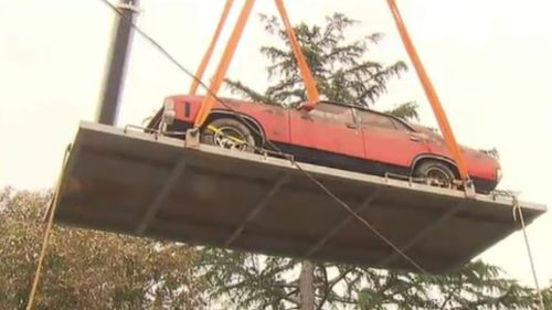 A 90-tonne crane was used to pluck the Ford from the backyard shed. (9NEWS)