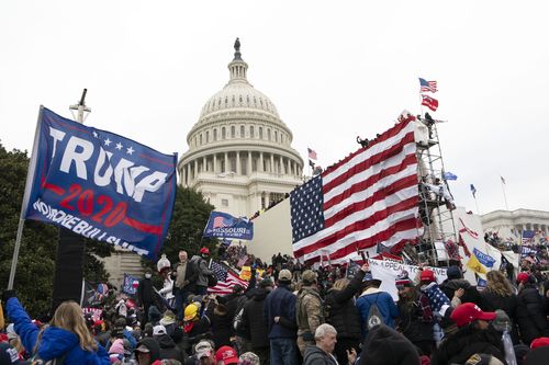 DOSSIER – Des insurgés violents fidèles au président Donald Trump se tiennent devant le Capitole américain à Washington le 6 janvier 2021. 