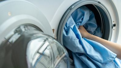 Person putting washing into a washing machine