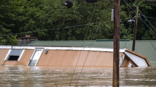 Homes are flooded by Lost Creek, Ky., on Thursday, July 28, 2022.  Heavy rains have caused flash flooding and mudslides as storms pound parts of central Appalachia. Kentucky Gov. Andy Beshear says it's some of the worst flooding in state history.  (Ryan C. Hermens/Lexington Herald-Leader via AP)