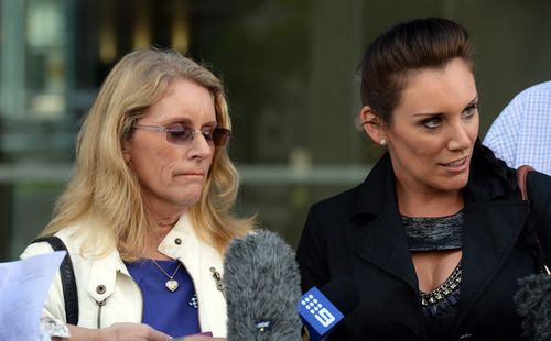 Julie Waters (left) and Hayley Sinton, mother and sister of murdered police officer Damian Leeding, speak to the media outside the Supreme Court in Brisbane, Friday, March 28, 2014. 