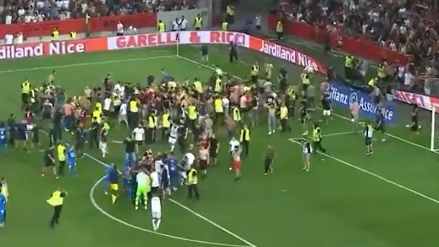 Fans invade the pitch as the match between Nice and Marseille is halted.
