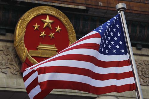 An American flag is flown next to the Chinese national emblem during a welcome ceremony at the Great Hall of the People in Beijing, November 9, 2017.  