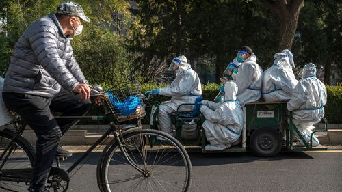 Trabajadores de control de epidemias viajan en un vehículo en un área de Beijing donde las comunidades están bajo encierro o control de salud para evitar la propagación de COVID-19