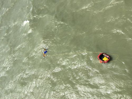 Three men were winched to safety 30km off the coast of Darwin when their boat sank.