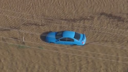 A car partially submerged in floodwaters at Jimboomba. (9NEWS)