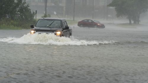 Kierowca jedzie mimo podnoszącej się wody, podczas gdy inny zawraca podczas huraganu Ian, piątek, 30 września 2022 r. w Charleston w Południowej Karolinie (AP Photo/Alex Brandon)