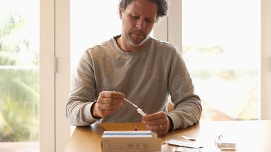 A man uses a COVID-19 rapid antigen test kit in Sydney.