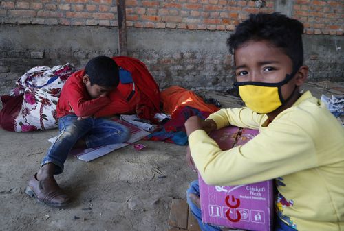 Children of Nepalese daily wage workers rest at a makeshift shelter after being stopped by policemen while they were on their way to their village, during lockdown to prevent the spread of COVID-19 in Lubu, on the outskirts of Lalitpur, Nepal.