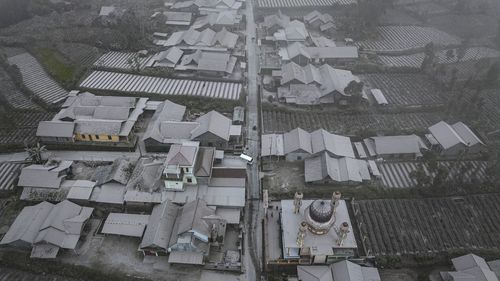 O vedere aeriană a caselor acoperite cu cenușă după erupția de material vulcanic de către Muntele Merapi din satul Stabilan pe 11 martie 2023 în Boyolali, Java Central, Indonezia.  Muntele Merapi, cu o înălțime de 2.968 de metri, este cunoscut drept unul dintre cei mai activi vulcani din Indonezia, cu o erupție la fiecare doi până la cinci ani. 