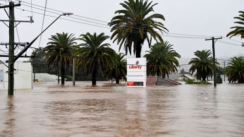 A petrol station sign shows the depth of the water.