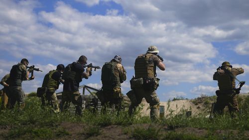 Civilian militia men hold rifles during training at a shooting range in outskirts Kyiv, Ukraine, Tuesday, June 7, 2022 