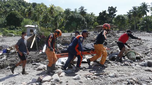 Rescuers carry a body at Maguindanao's Datu Odin Sinsuat town, southern Philippines on Sunday Oct. 30, 2022. 