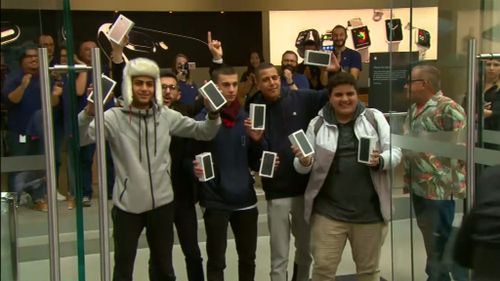 After two days of waiting the boys exited the store with their new phones, all smiles. (9NEWS)