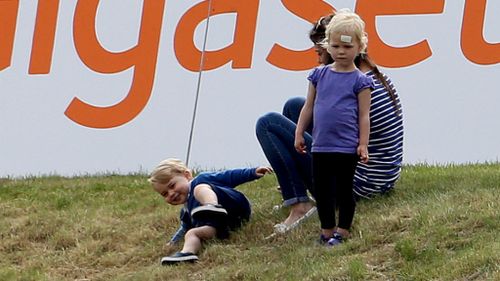 Prince George rolls about on the grass. (Steve Parsons/PA Wire)