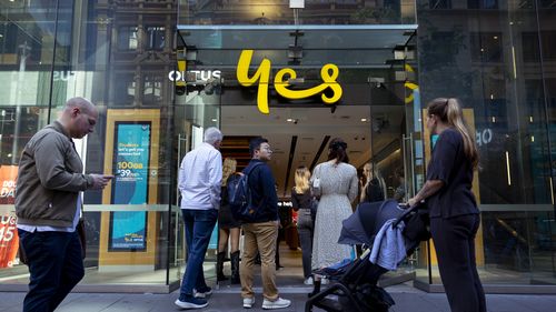 Customers line up outside an Optus shop fron