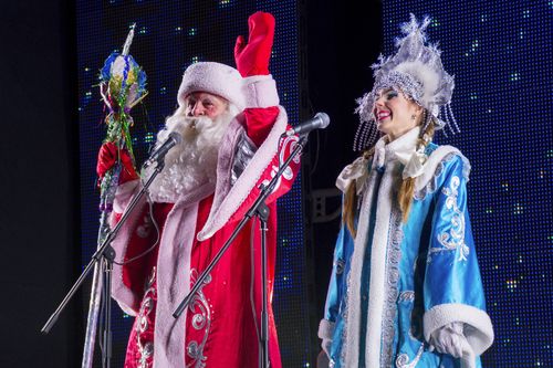 Актеры, одетые как Дед Мороз (Санта-Клаус) или Дед Мороз, как Снегурочка (Снегурочка) приветствуют людей, собравшихся у украшенной елки на празднование Рождества и Нового года в Луганске, столице подконтрольной России Луганской области, восточная Украина, пятница. 23 декабря 2022 г. 