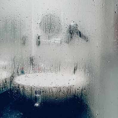 Looking through a foggy, wet window into a bathroom