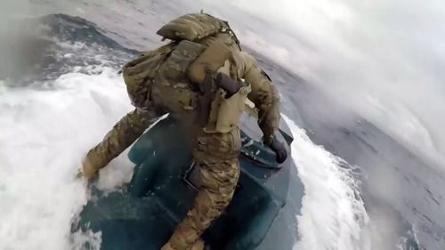 A US Coast Guardsman jumped onto a homemade submarine.