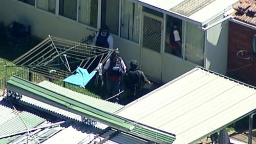 Police search the backyard of a property in Guildford. (9NEWS)