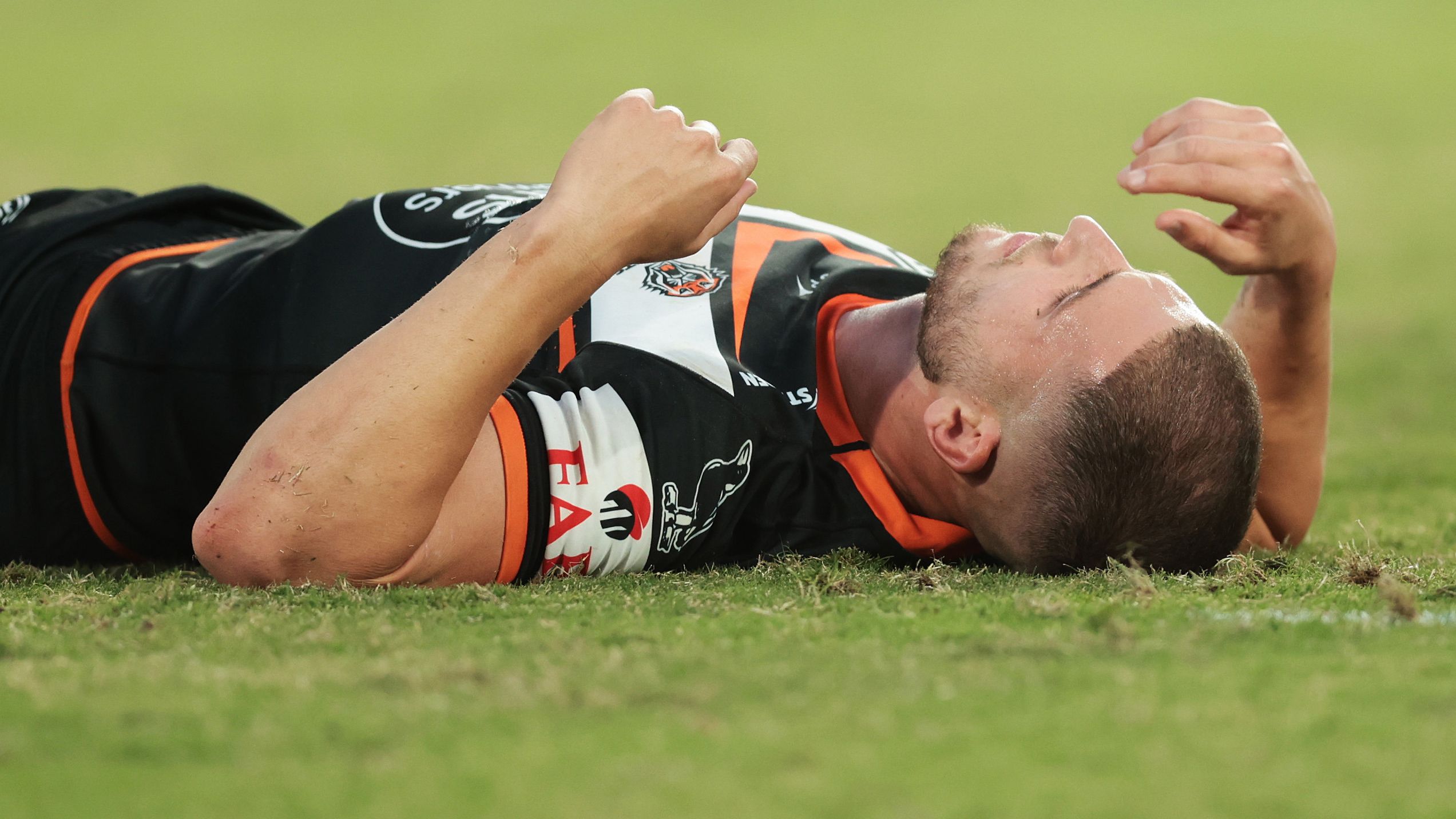 Adam Doueihi of the Wests Tigers lays on the field injured during the round six NRL match between Wests Tigers and Parramatta Eels at Accor Stadium on April 10, 2023 in Sydney, Australia. (Photo by Mark Metcalfe/Getty Images)