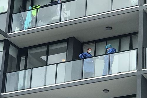 Police examine the balcony where the woman plunged from. (9NEWS)