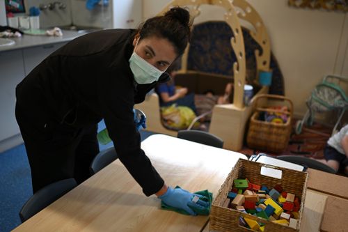 Early childhood educator Josephine wipes down tables and bench tops with disinfectant at the Robertson Street Kindy Childcare Centre in Helensburgh south of Sydney, Friday, April 3, 2020.