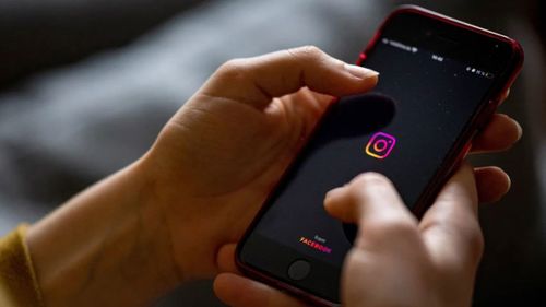 The logo of the Instagram app is seen on the screen of a smartphone in 2021.