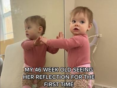 Baby discovers her reflection in the mirror.