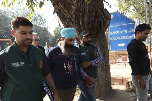 Policemen escort Rajwinder Singh, 38, after he was arrested in New Delhi, India, Friday, Nov. 25, 2022. The Indian nurse accused of killing Toyah Cordingley, 24, an Australian woman in Queensland in 2018 was arrested by Delhi Police on Friday. The Queensland Police had offered a reward of 1 million Australian dollars for information leading to Singh's arrest. (AP Photo/Dinesh Joshi)