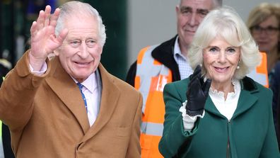 King Charles III and Queen Camilla smile and wave during the launch of the Coronation Food Project and the visit to the South Oxfordshire Food and Education Alliance, a surplus food distribution centre, on November 14, 2023 in Didcot, England. 