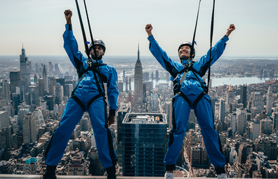 City Climb: Two visitors leaning off a building with harnesses