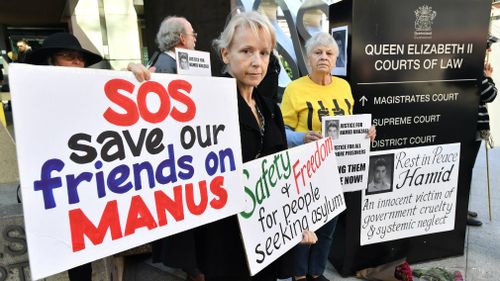 Protester Jillian Oldfield (left) from the Refugee Action Collective is seen during a vigil for deceased asylum seeker Hamid Khazaei outside the Brisbane Magistrates Court. Picture: AAP