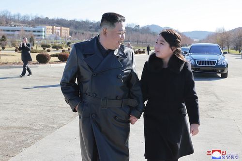 This undated photo provided on Nov. 27, 2022, by the North Korean government shows North Korean leader Kim Jong Un, left, and his daughter, right, walk to a photo session with those involved in the recent launch of what it says a Hwasong-17 intercontinental ballistic missile, at an unidentified location in North Korea. 