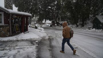 A resident walks to a restaurant during a storm in Mount Baldy, California, on Friday.