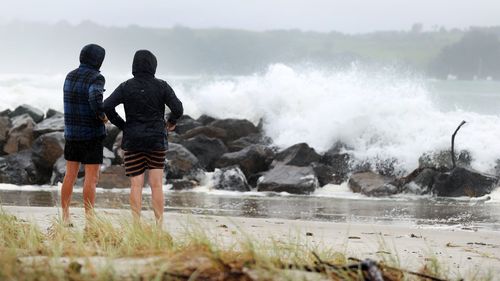People out looking at the effects of Cyclone Gabrielle at Omaha Beach on February 13 in Auckland, New Zealand. 