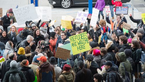 Trump's executive order has sparked protests, with a group gathering outside New York's JFK airport. (AFP)