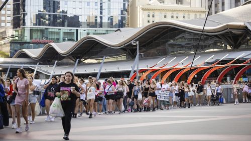 A long line of fans is seen stretching around the Southern Cross Station Concourse to Marvel Stadium in the lead up to the Harry Styles concert.