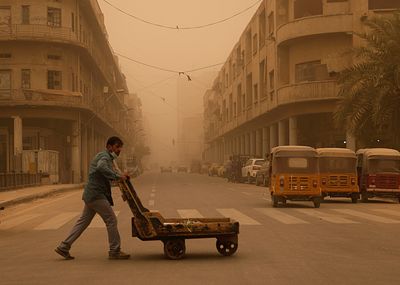 A man pushes a cart during a sandstorm in Baghdad, Iraq, Monday, May 23, 2022. (AP Photo/Hadi Mizban)