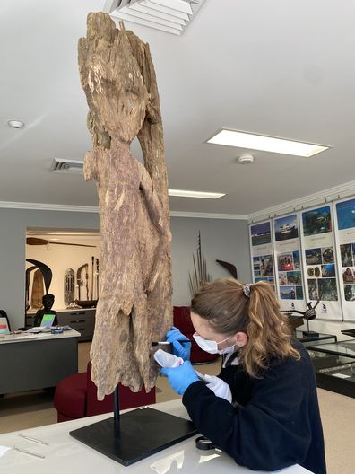 Heather Berry performs a vacuum conservation treatment on an ossuary door from the Silentworld Foundation collection.